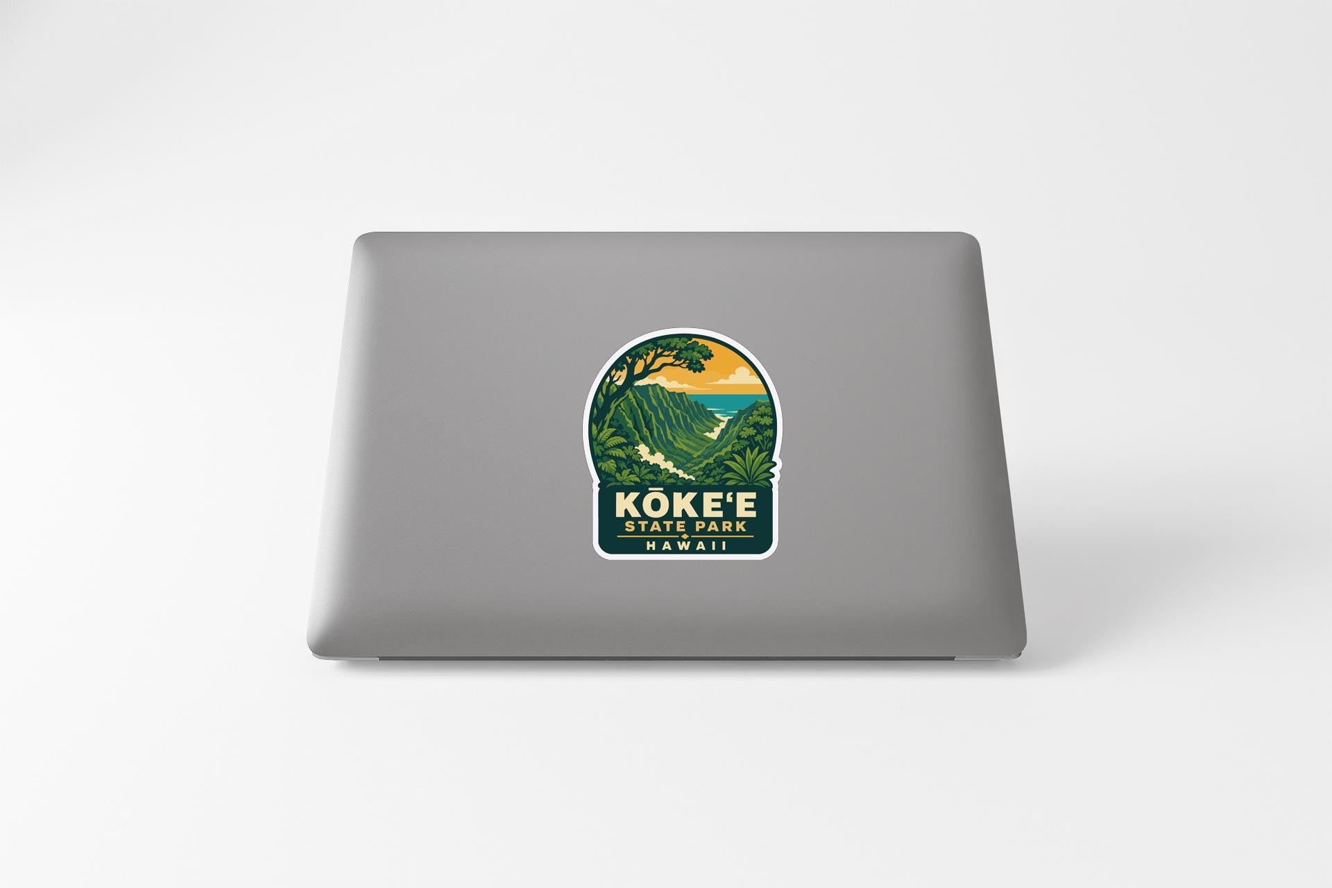 a sticker on the back of a laptop, depicting a scenic landscape with mountains and a body of water.