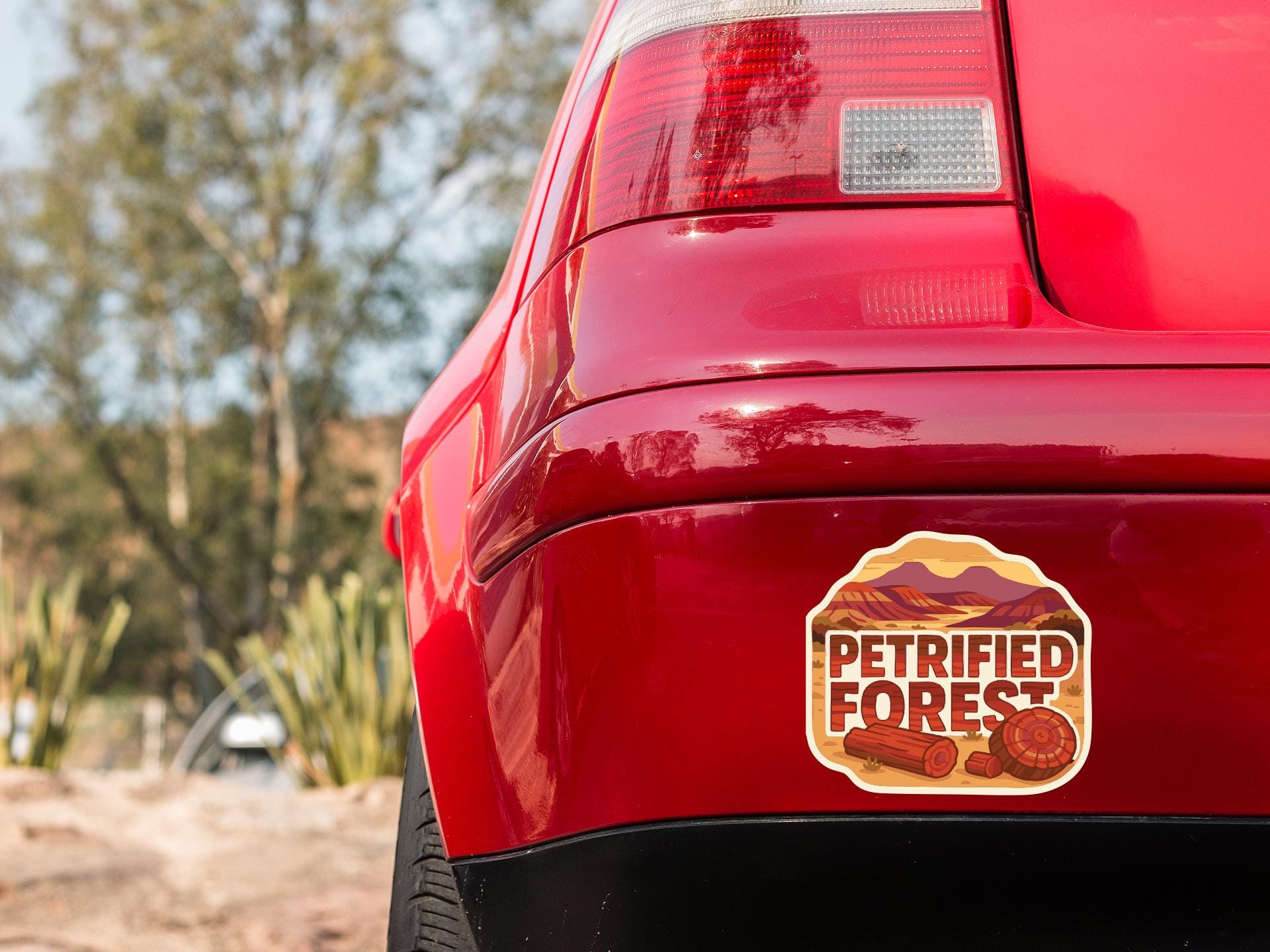the rear end of a red car with a sticker on the back that says "Petrified Forest".