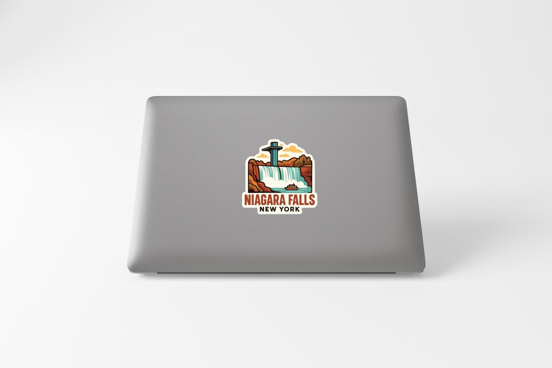 A sticker on the back of a laptop that features an illustration of Niagara Falls, New York.