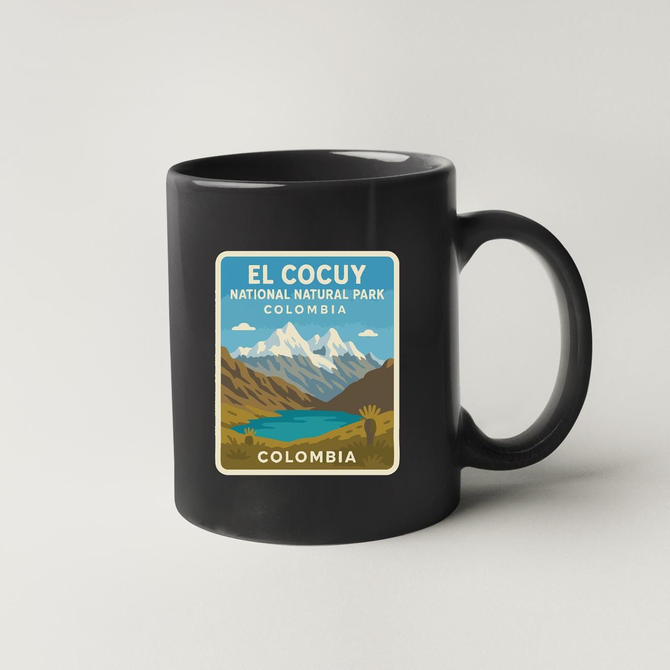 A black coffee mug with a label that says "EL COCUY NATIONAL NATURAL PARK COLOMBIA".