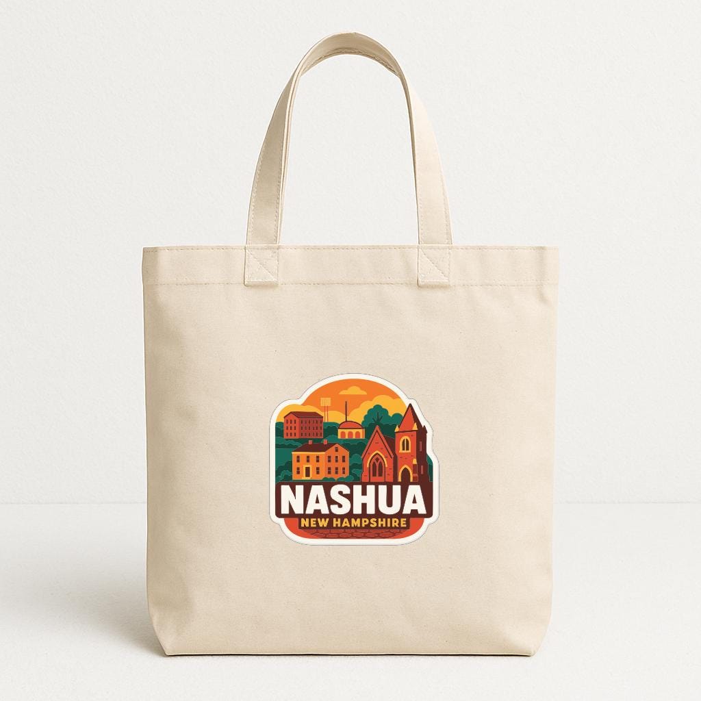 A beige tote bag with a graphic design featuring a cityscape and the text "NASHUA NEW HAMPSHIRE" printed on it.