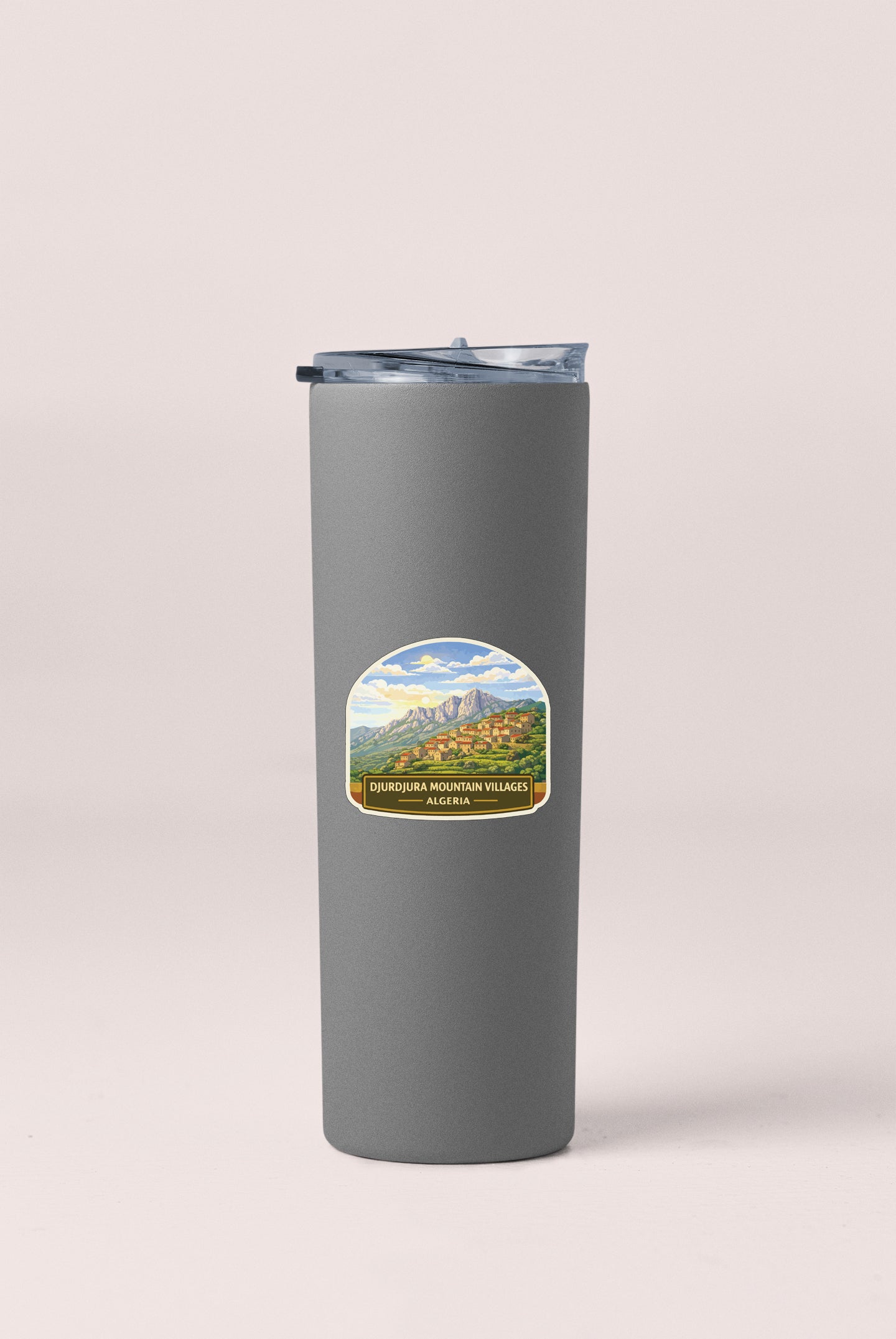 A gray insulated tumbler with a label that says "DUROURIER MOUNTAIN VILLAGES ALGRABIA".