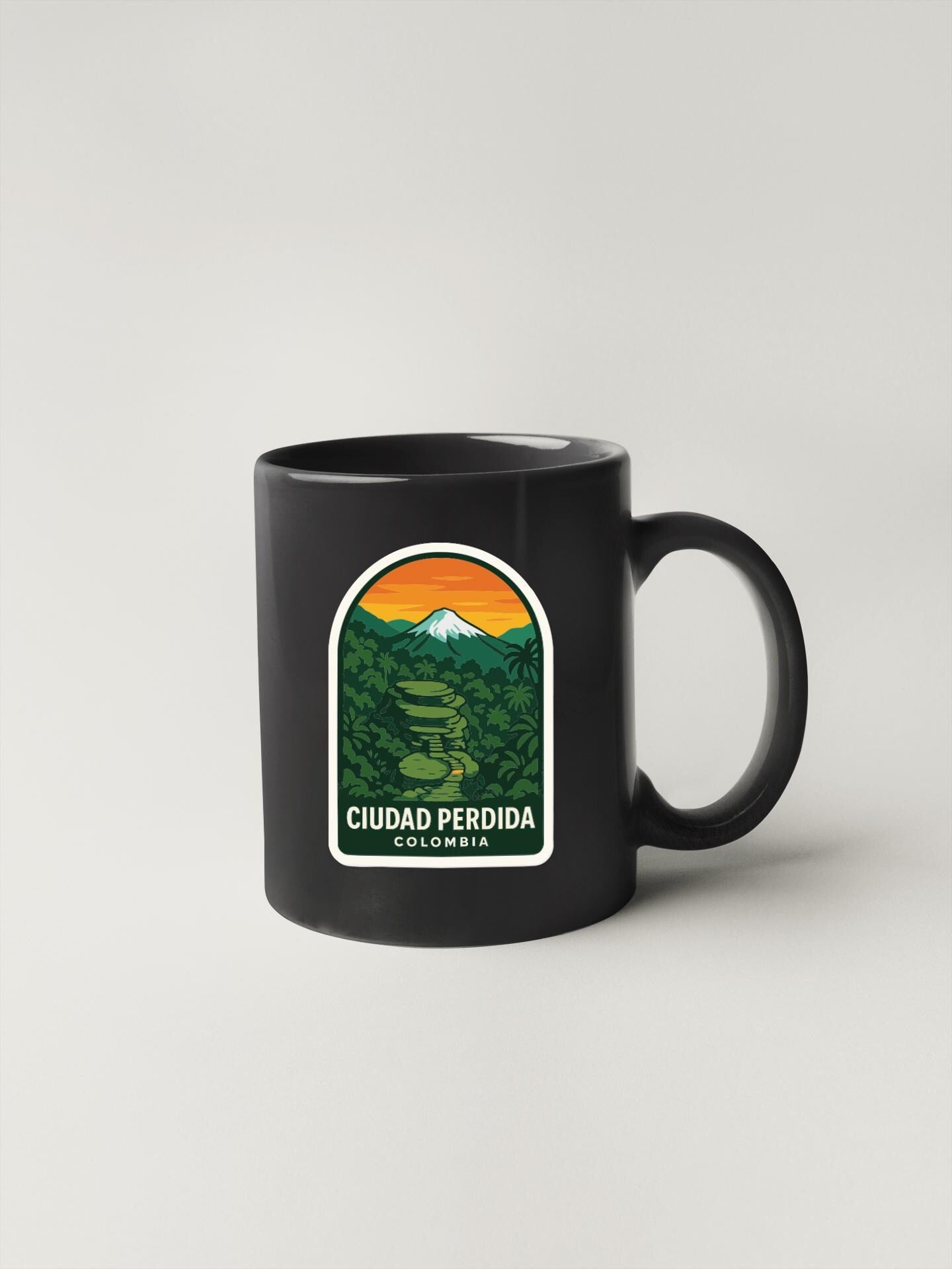 A black coffee mug with a graphic design depicting a mountain landscape and a path leading through the forest.
