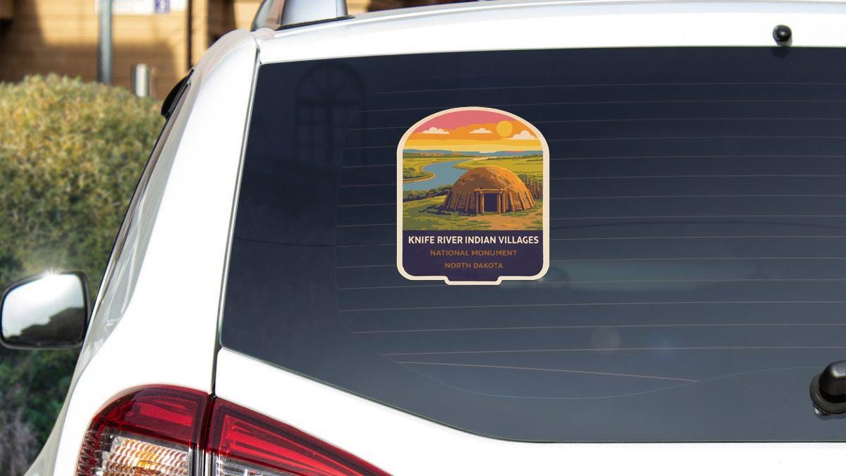 a sticker on the rear window of a white car, depicting a Native American village with a hut and a river.