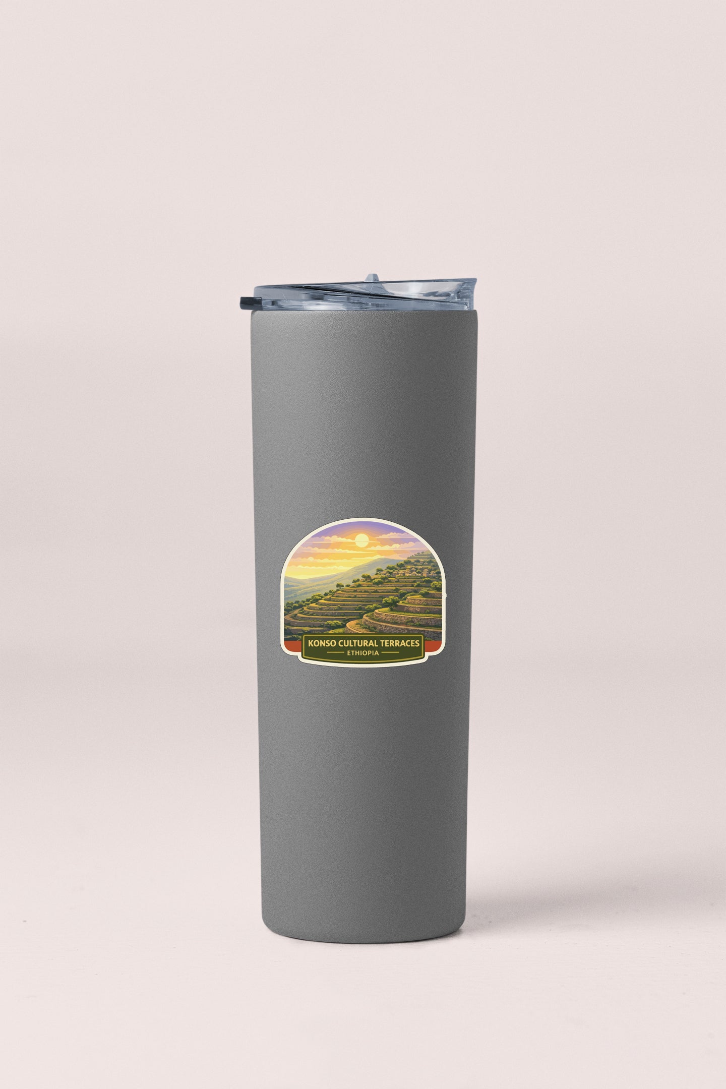 A gray insulated tumbler with a label depicting a scenic landscape.