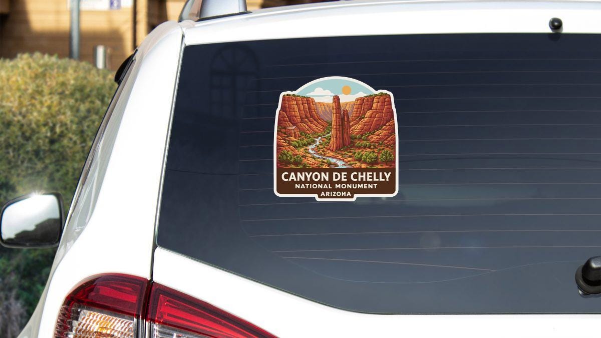 A sticker on the rear window of a car, depicting the Canyon de Chelly National Monument in Arizona.