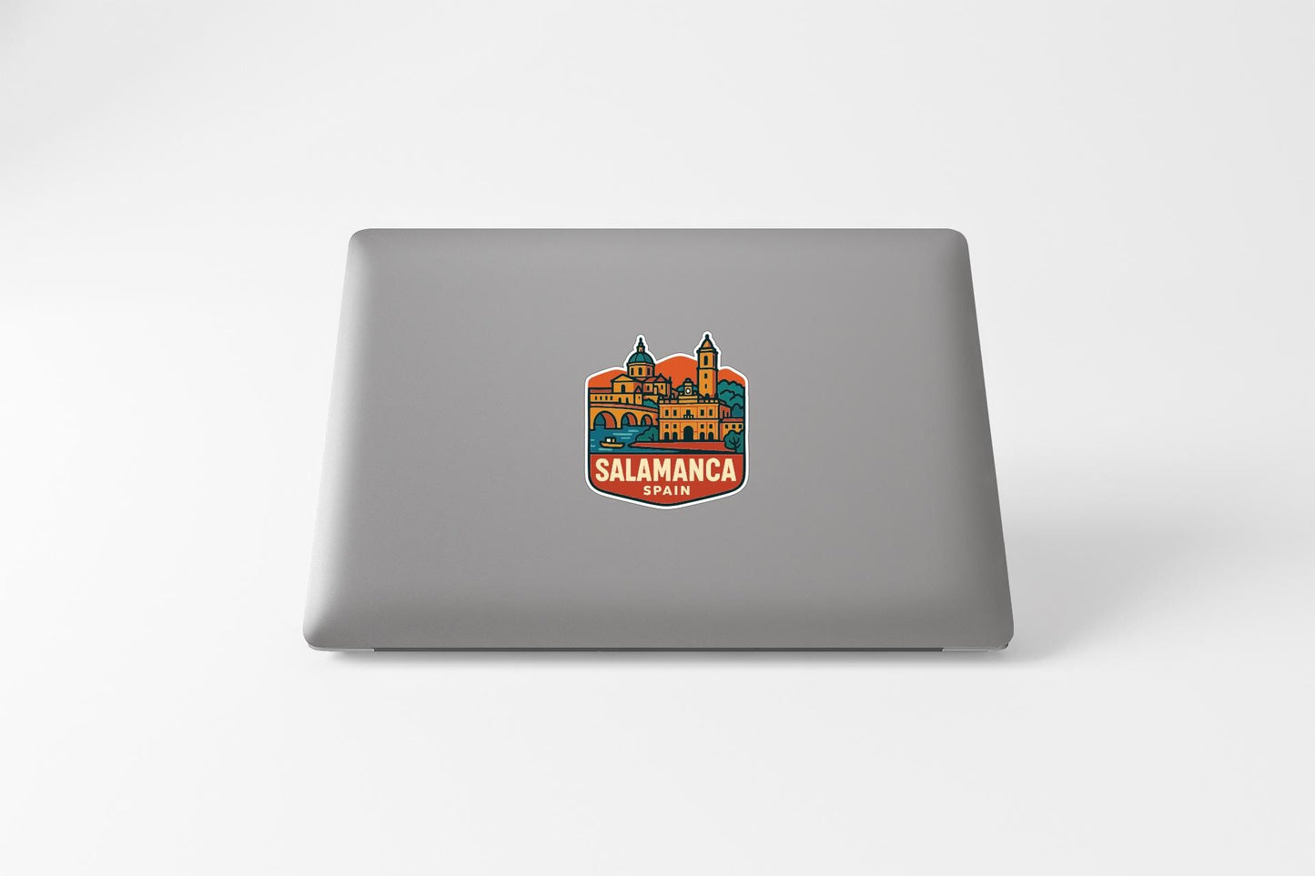 a sticker with a colorful illustration of a building and the text "Salamanca" on a laptop.