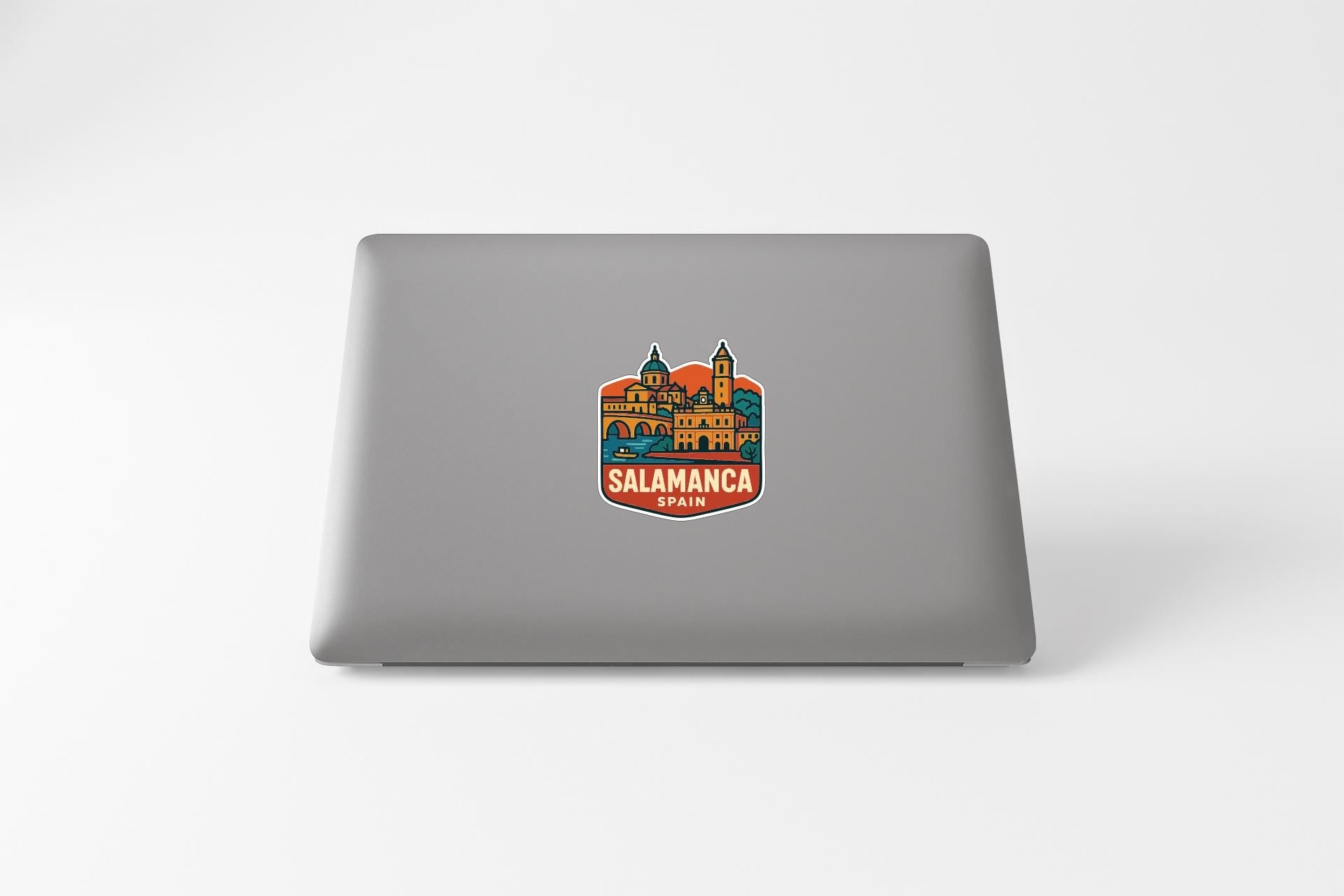 a sticker with a colorful illustration of a building and the text "Salamanca" on a laptop.