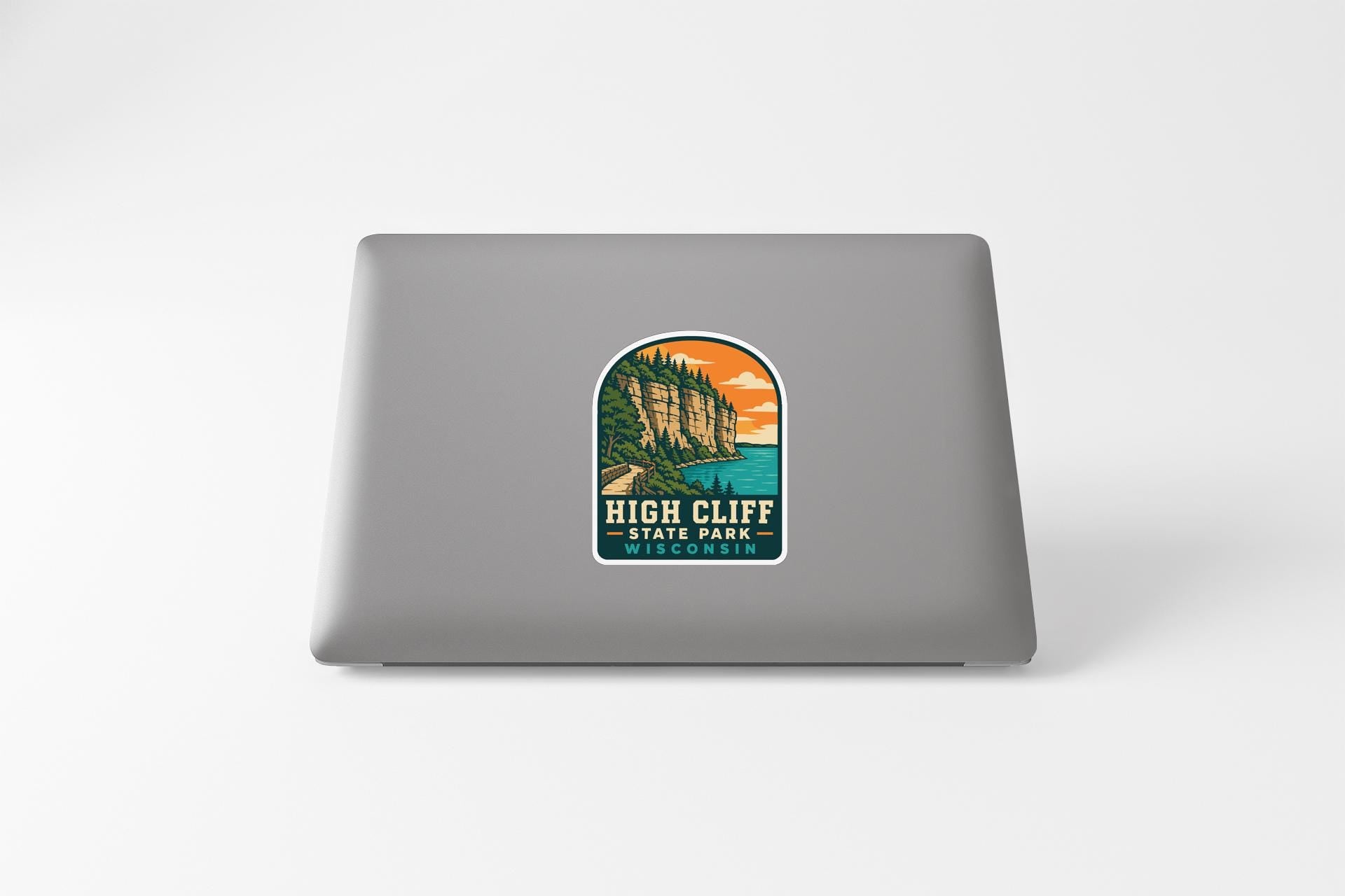 A sticker featuring a scenic landscape with a cliff and a lake, representing High Cliff State Park.