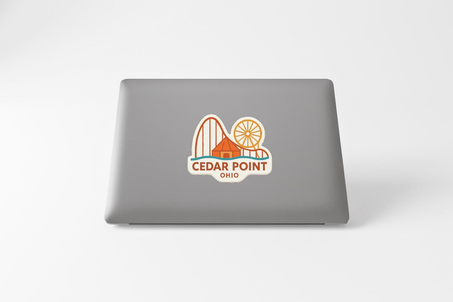 a sticker with a graphic of a roller coaster and the text "Cedar Point Ohio" on a laptop.