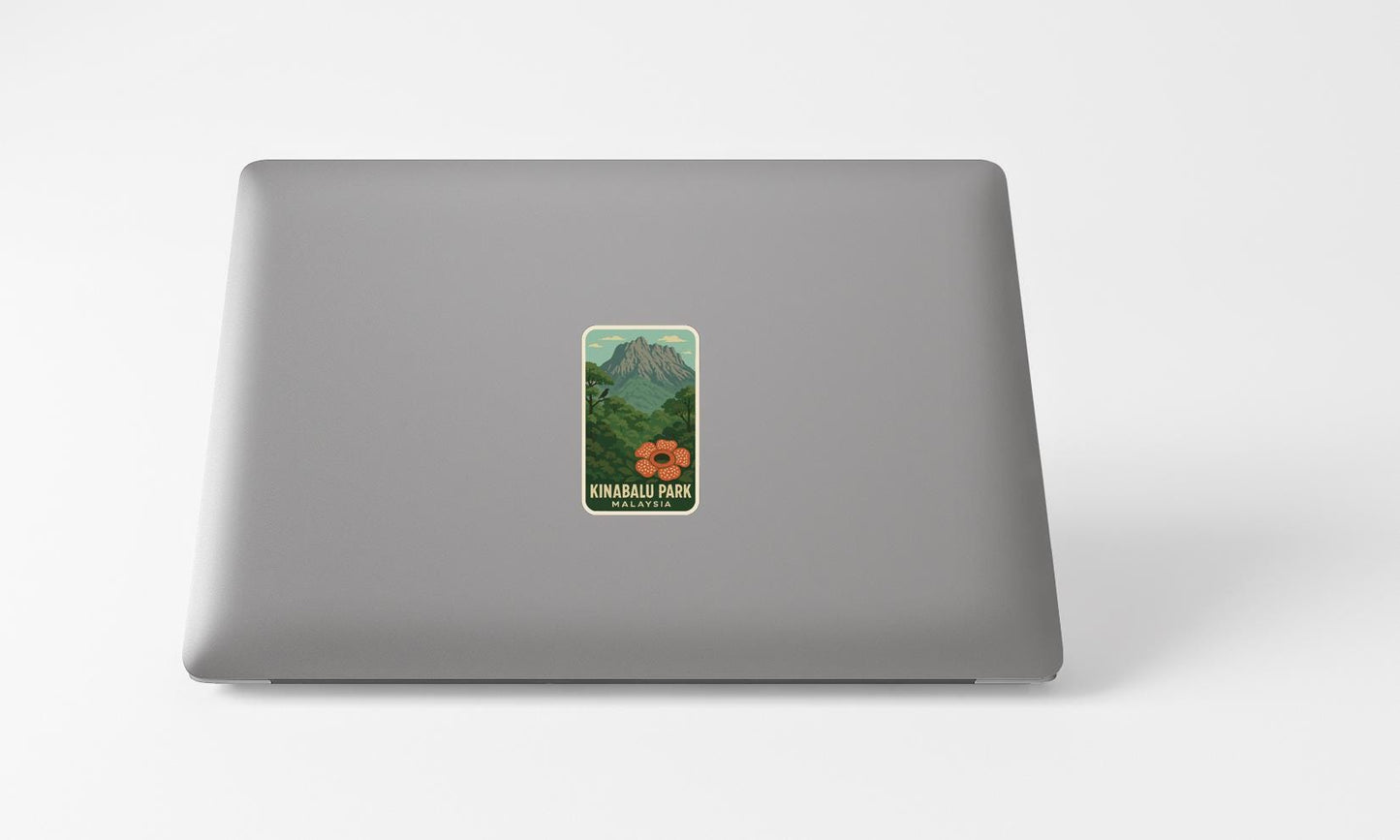 A sticker depicting a mountain landscape with a flower on it, placed on the back of a laptop computer.