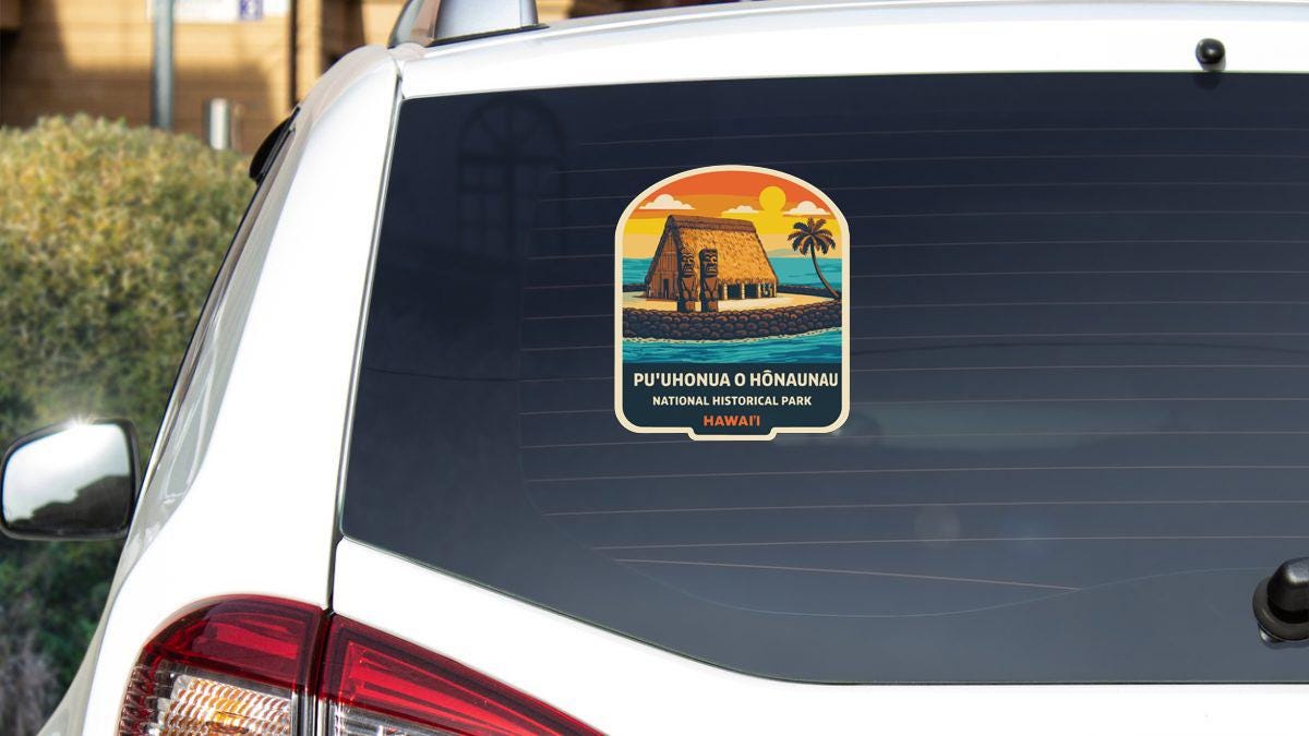 A sticker on the rear window of a car, depicting a tropical scene with a house and palm trees.