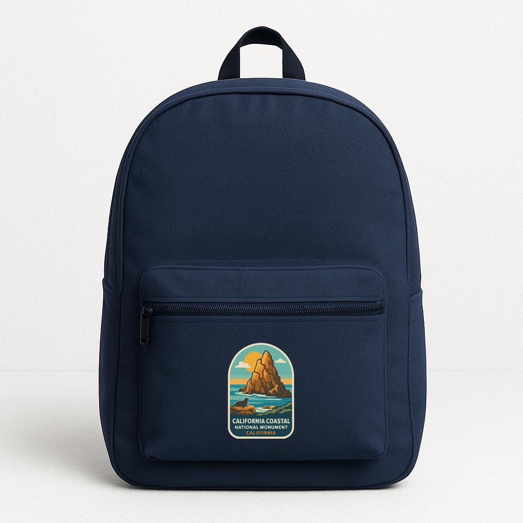 A navy blue backpack with a California Coastal National Monument patch on the front.