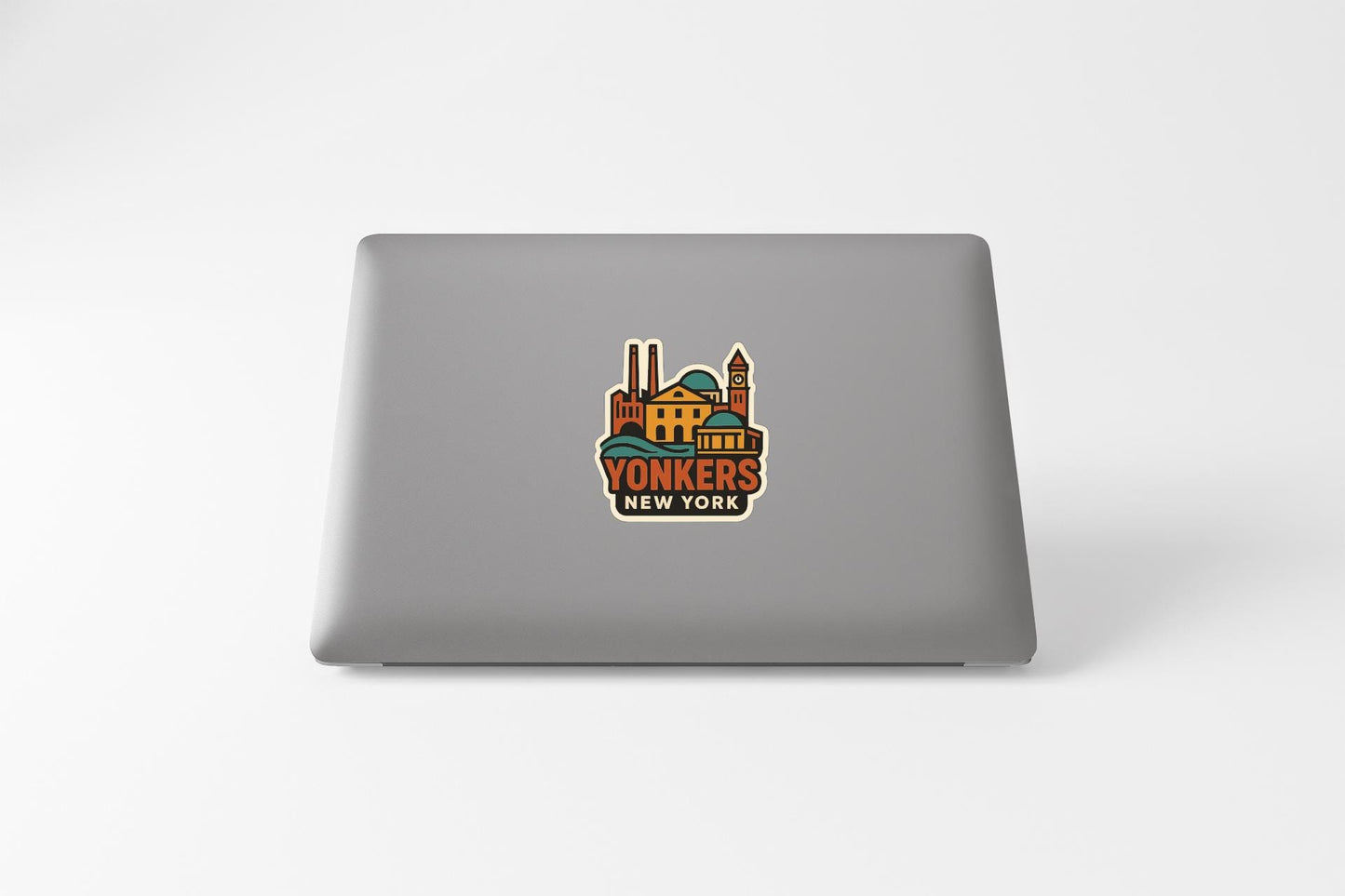 a sticker with a colorful illustration of a building and the text "YONKERS NEW YORK" on the back of a laptop.