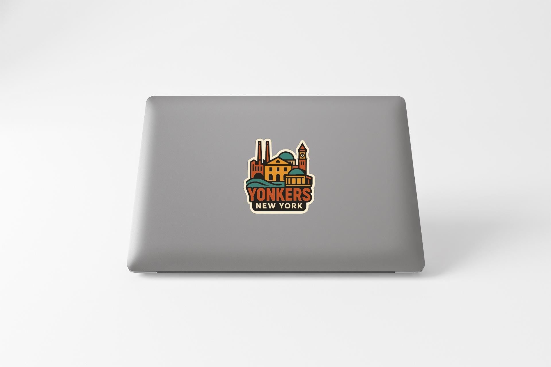 a sticker with a colorful illustration of a building and the text "YONKERS NEW YORK" on the back of a laptop.