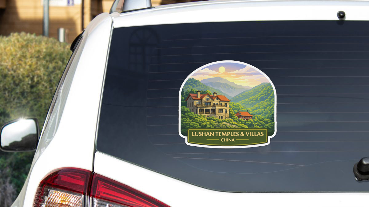 A sticker on the rear window of a car, depicting a scenic landscape with a house and mountains in the background.
