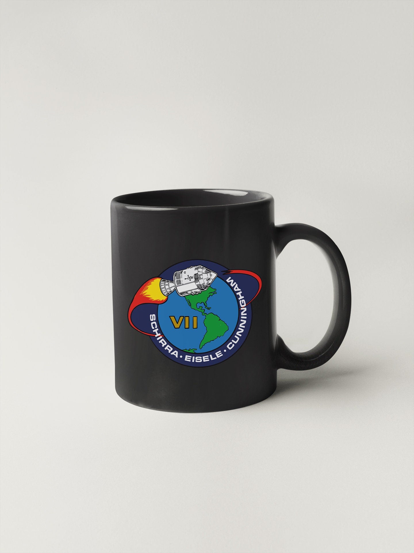 a black coffee mug with a nasa emblem on it
