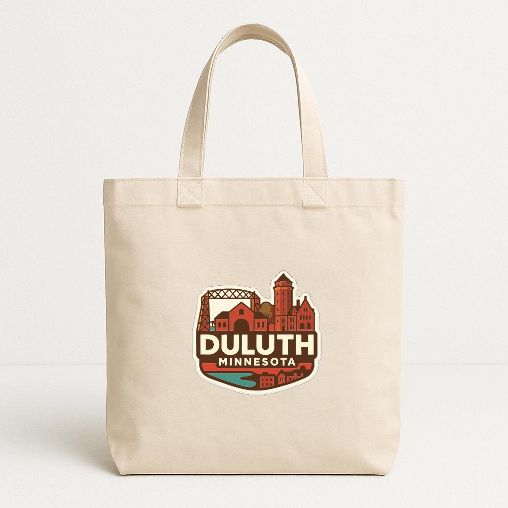 A beige tote bag with a printed design featuring the text "DULUTH MINNESOTA" and an illustration of a cityscape.