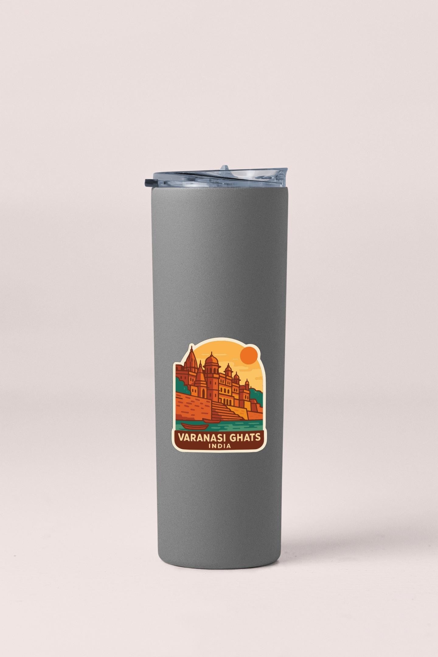 A gray insulated tumbler with a sticker depicting a temple and the text "VARANASI GHATS INDIA".