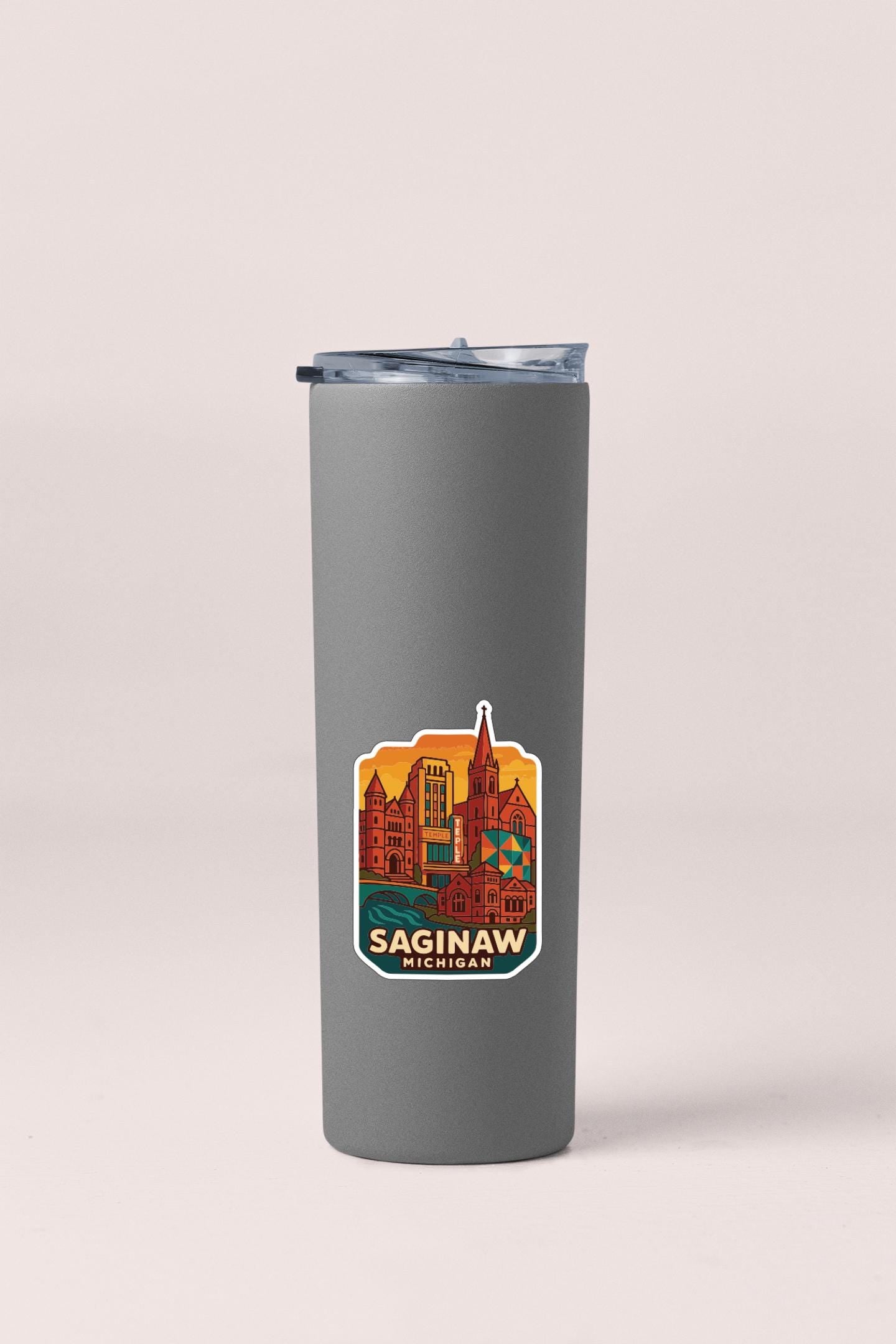 A gray insulated tumbler with a sticker depicting the city of Saginaw, Michigan.