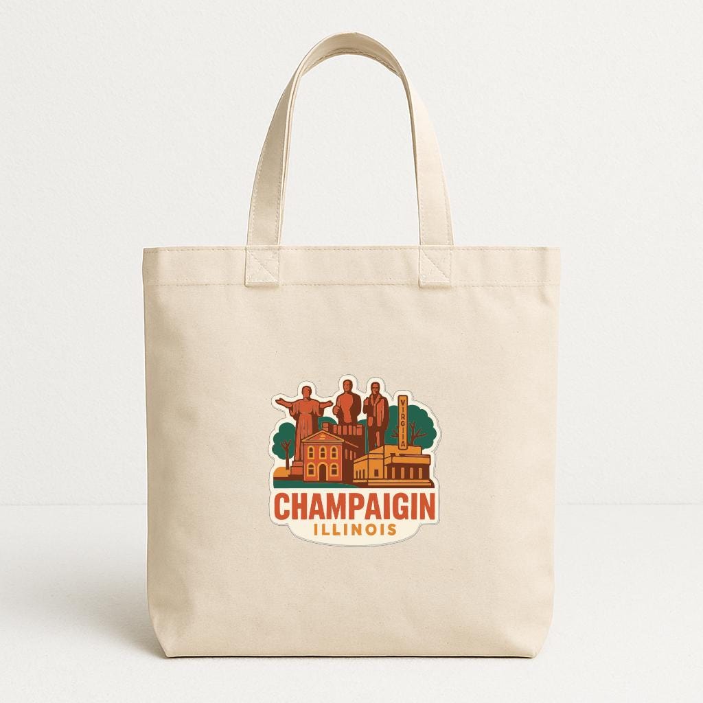 A beige tote bag with a printed design depicting the Champaign, Illinois area.