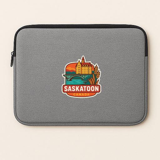 A gray laptop sleeve with a colorful sticker depicting a cityscape and the word "Saskatoon" printed on it.