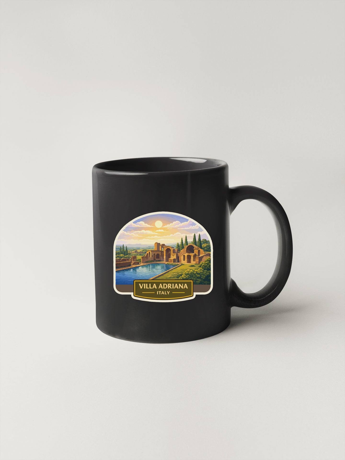 A black coffee mug with a printed image of a scenic landscape and the text "VILLA ADRIANA ITALY" printed on it.