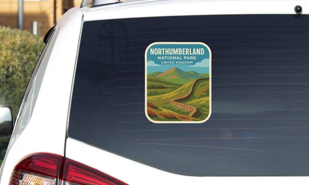 A sticker on the rear window of a car that says "NORTHUMBERLAND NATIONAL PARK UNITED KINGDOM".