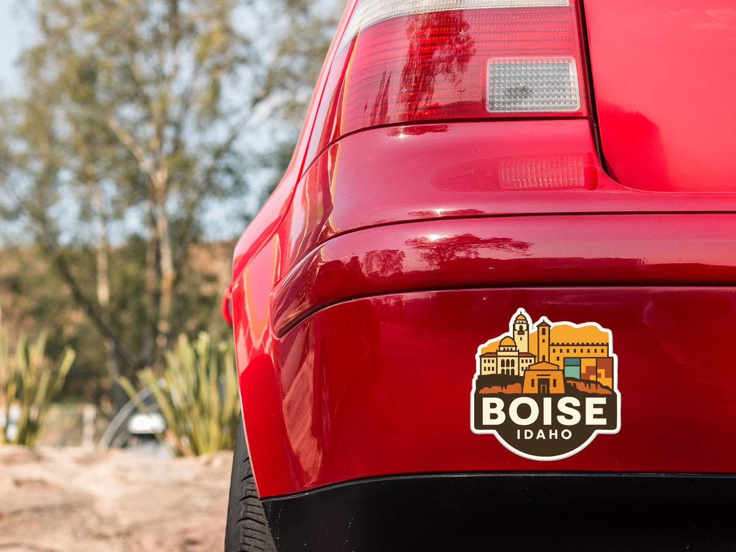 the rear end of a red car with a sticker on the trunk that says "Boise Idaho".
