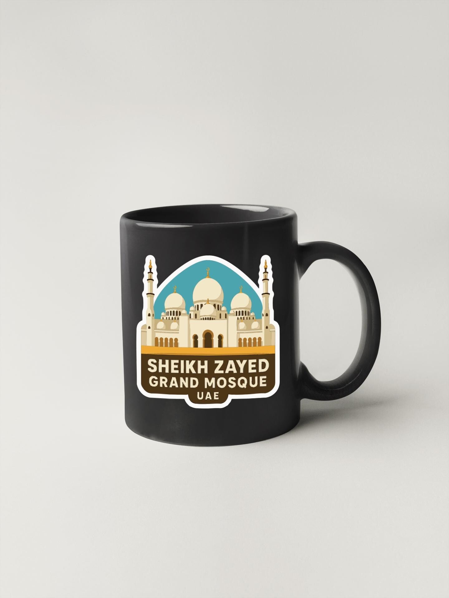A black coffee mug with a sticker depicting the Sheikh Zayed Grand Mosque in Abu Dhabi, United Arab Emirates.