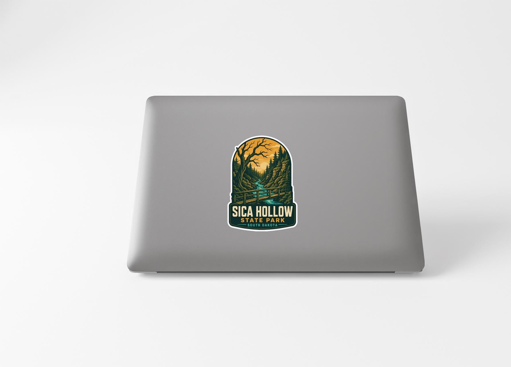a sticker with a scenic landscape of a forest and a river, along with the text "SICA HOLDW" and "STATE PARK".