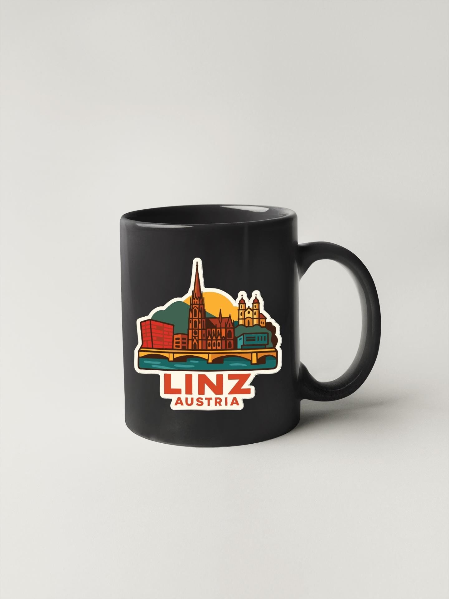 A black coffee mug with a colorful illustration of the Linz, Austria skyline.