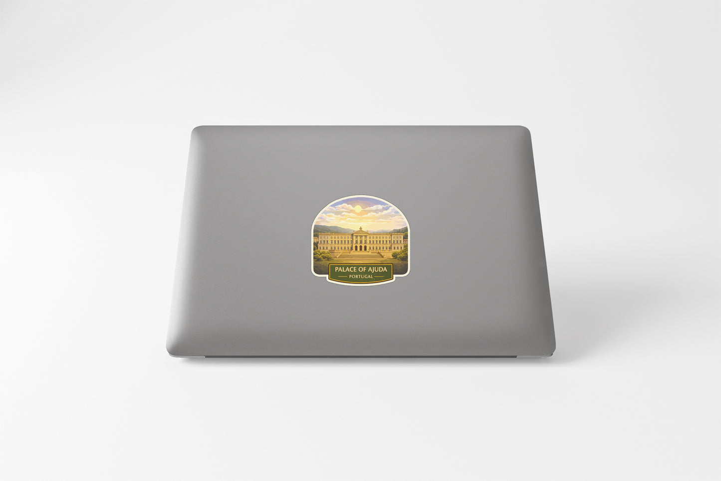 a sticker on the back of a laptop, depicting a building with a sunset in the background.