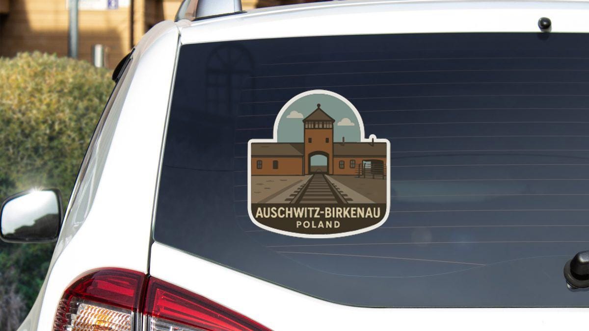 a sticker on the rear window of a car that displays the name 'AUSCHWITZ-BIRKENAU POLAND'.