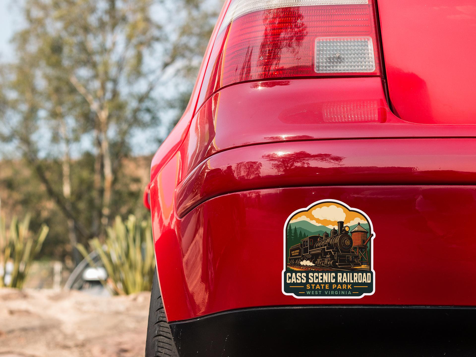 the rear end of a red car with a sticker on the trunk that says "CASS SCENIC RAILROAD STATE PARK WISCONSIN".