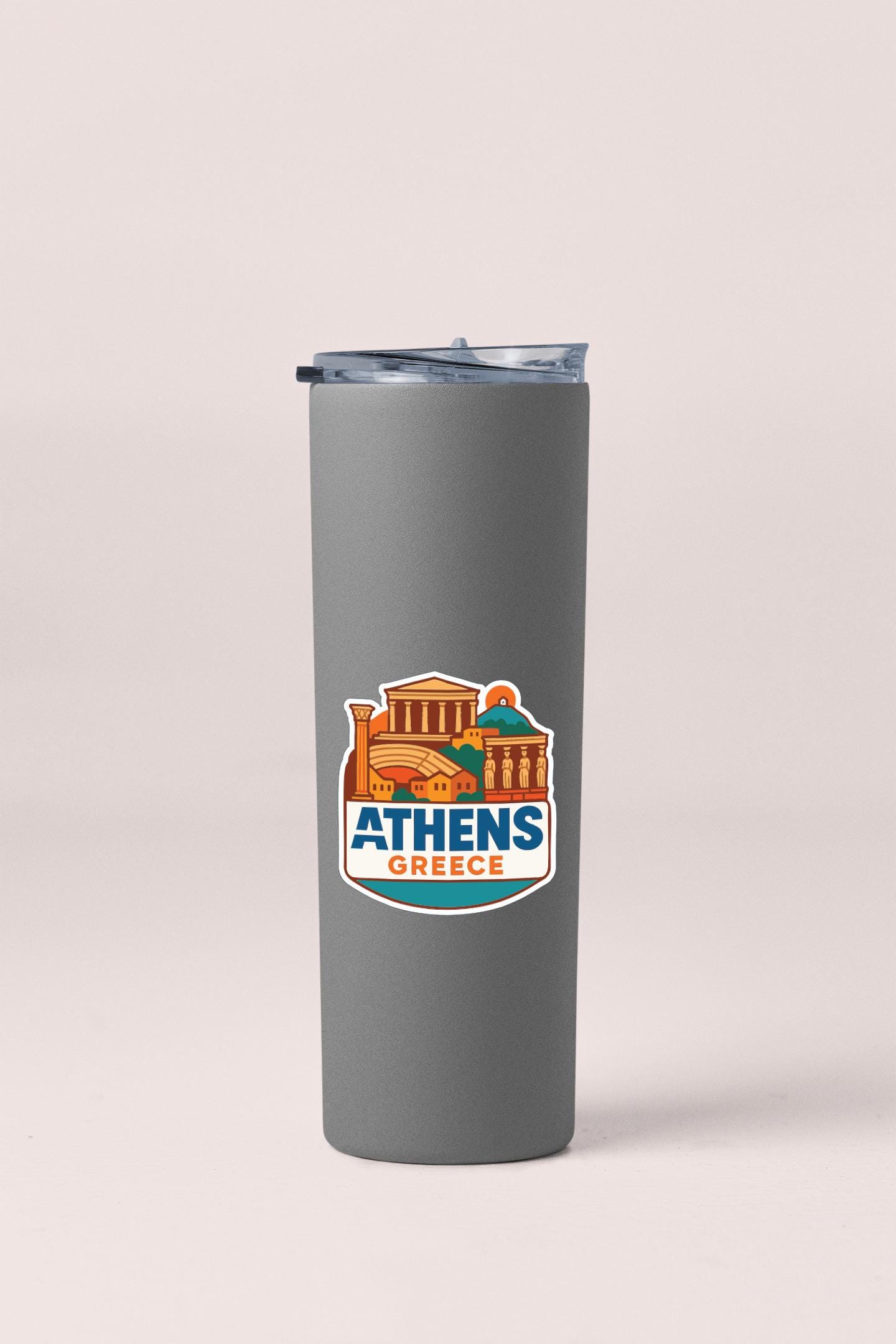 A gray insulated tumbler with a sticker depicting the city of Athens, Greece.