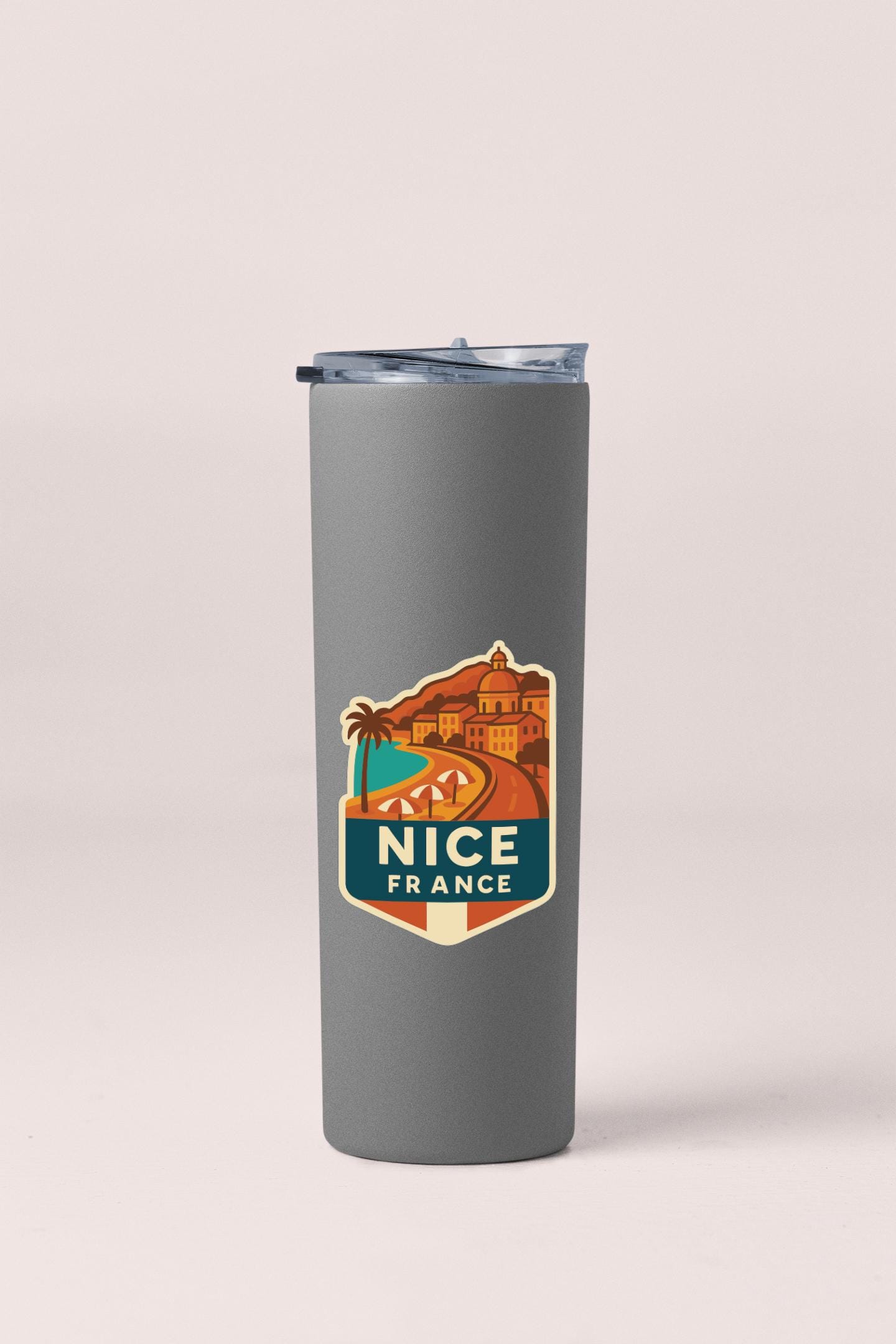 A gray insulated tumbler with a travel-themed sticker on it.