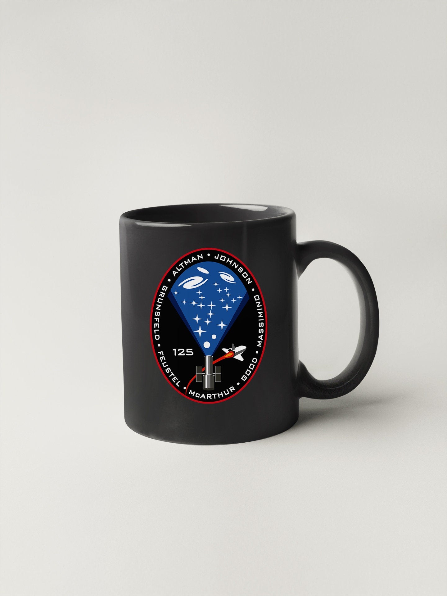 a black coffee mug with a nasa emblem on it