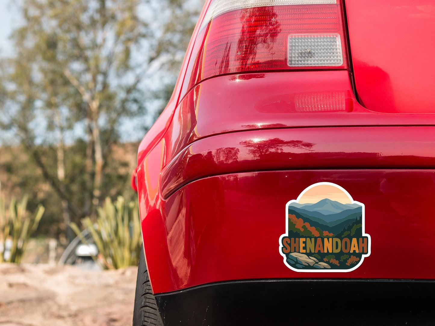 the rear end of a red car with a sticker on the trunk that says "Shenandoah".