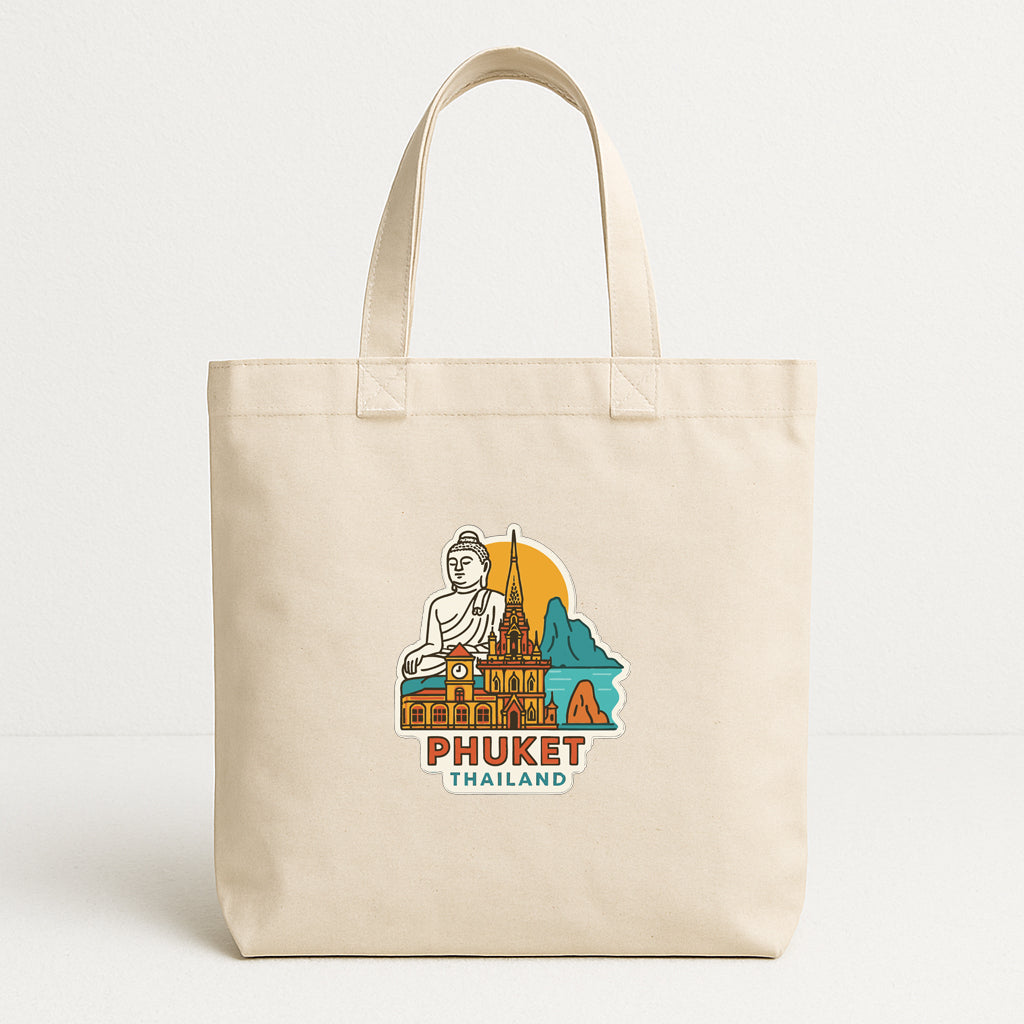 A beige tote bag with a printed design depicting a Buddha statue and buildings in the background, along with the text "PHUET THAILAND".