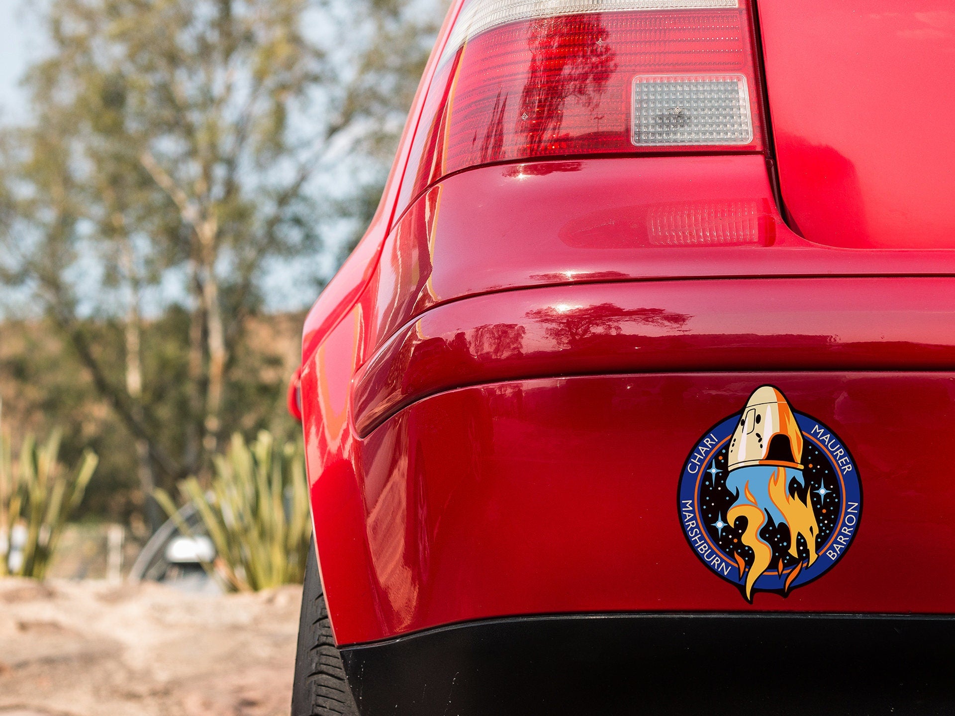the rear end of a red car with a logo on it