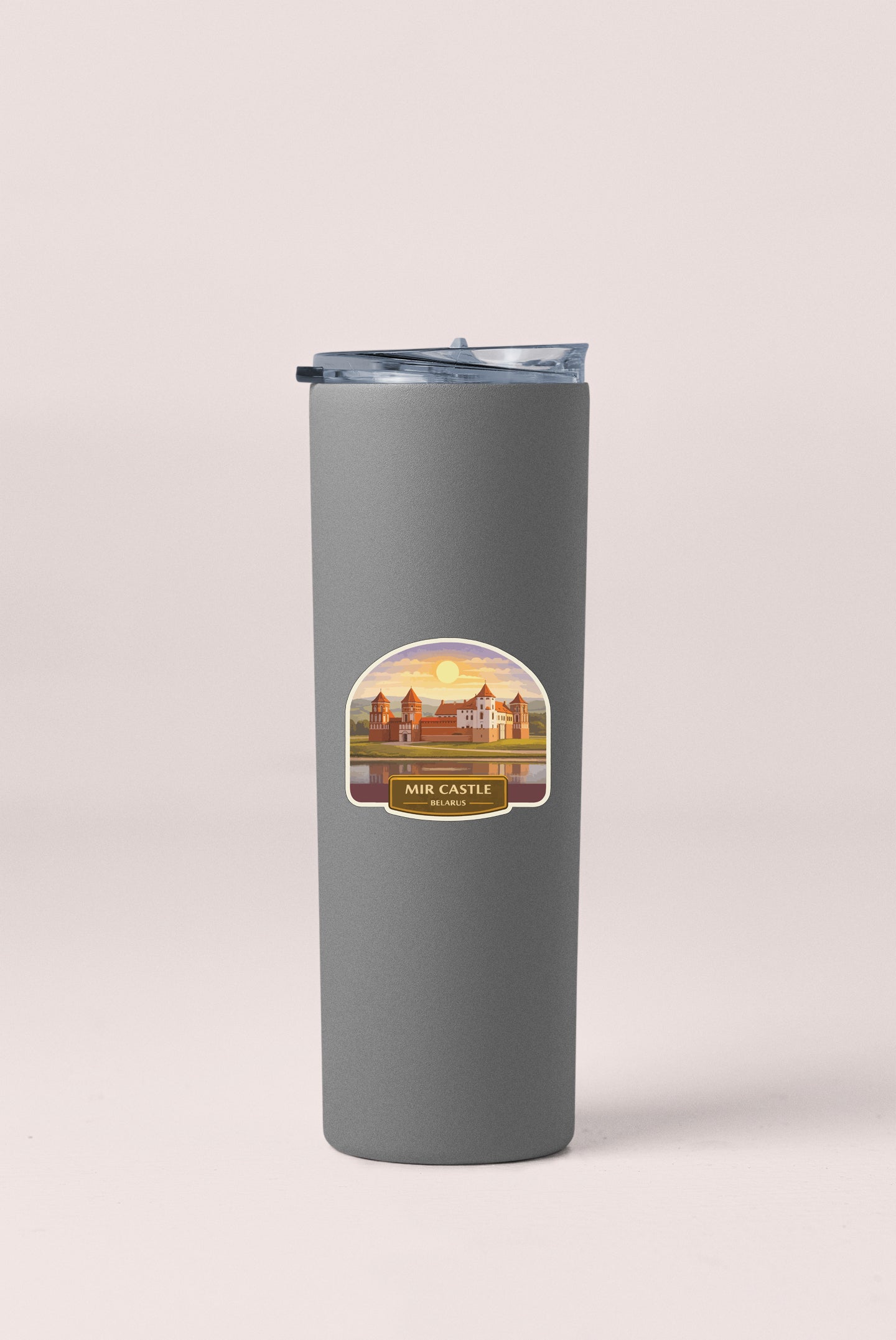 A gray insulated tumbler with a label that says "MIR CASTLE" and features an illustration of a castle and a sunset.