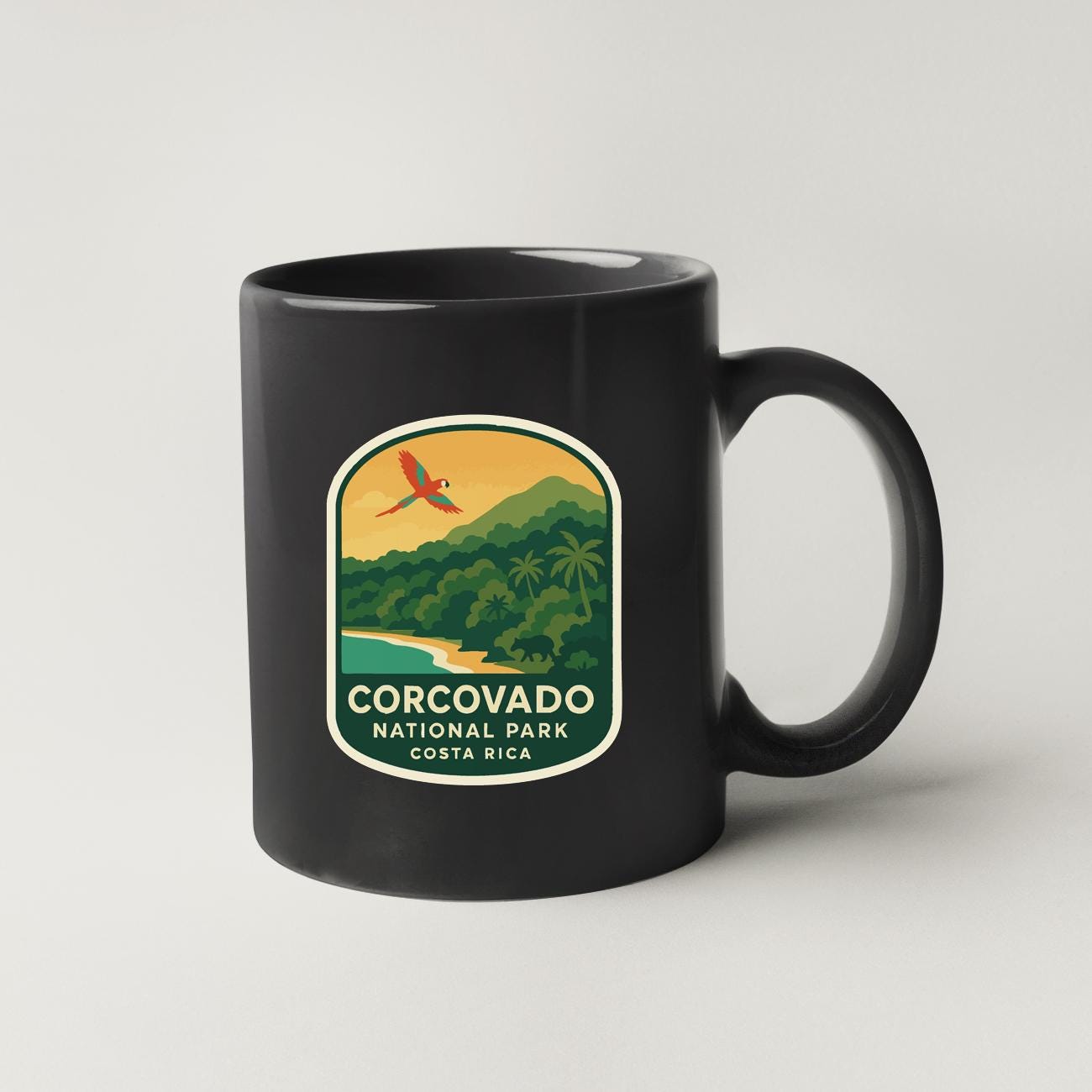 A black coffee mug with a label that says "CORCOVADO NATIONAL PARK, COSTA RICA".