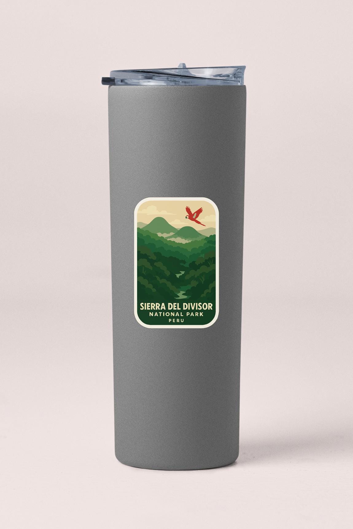 A gray insulated tumbler with a label that says "Sierra del División National Park" and features a mountain landscape with a red bird in flight.