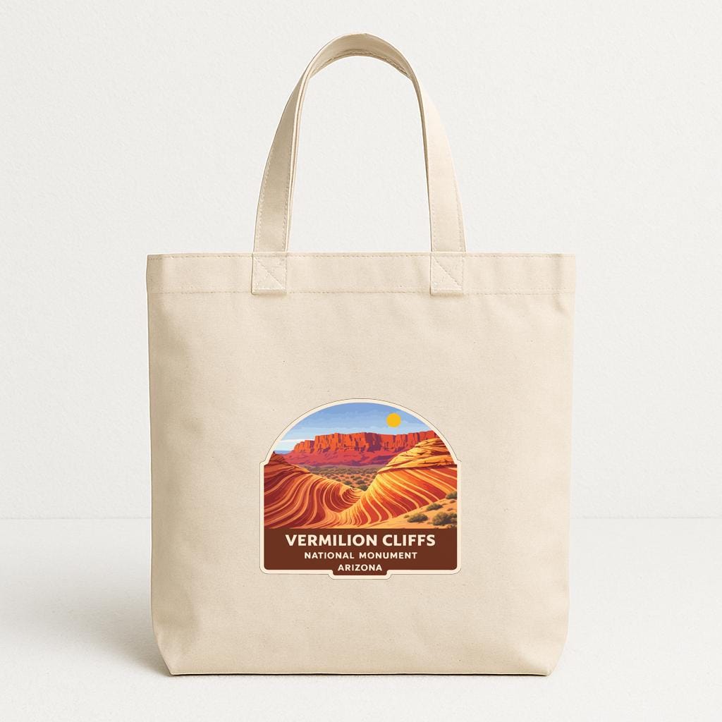 A beige tote bag with a label that features an illustration of the Vermilion Cliffs National Monument in Arizona.