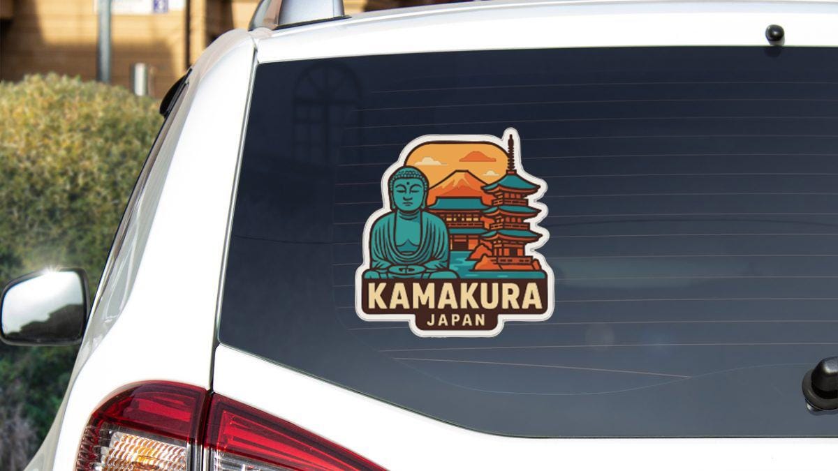 A sticker on the rear window of a car, depicting a temple and a Buddha statue, with the text "KAMAKURA JAPAN".