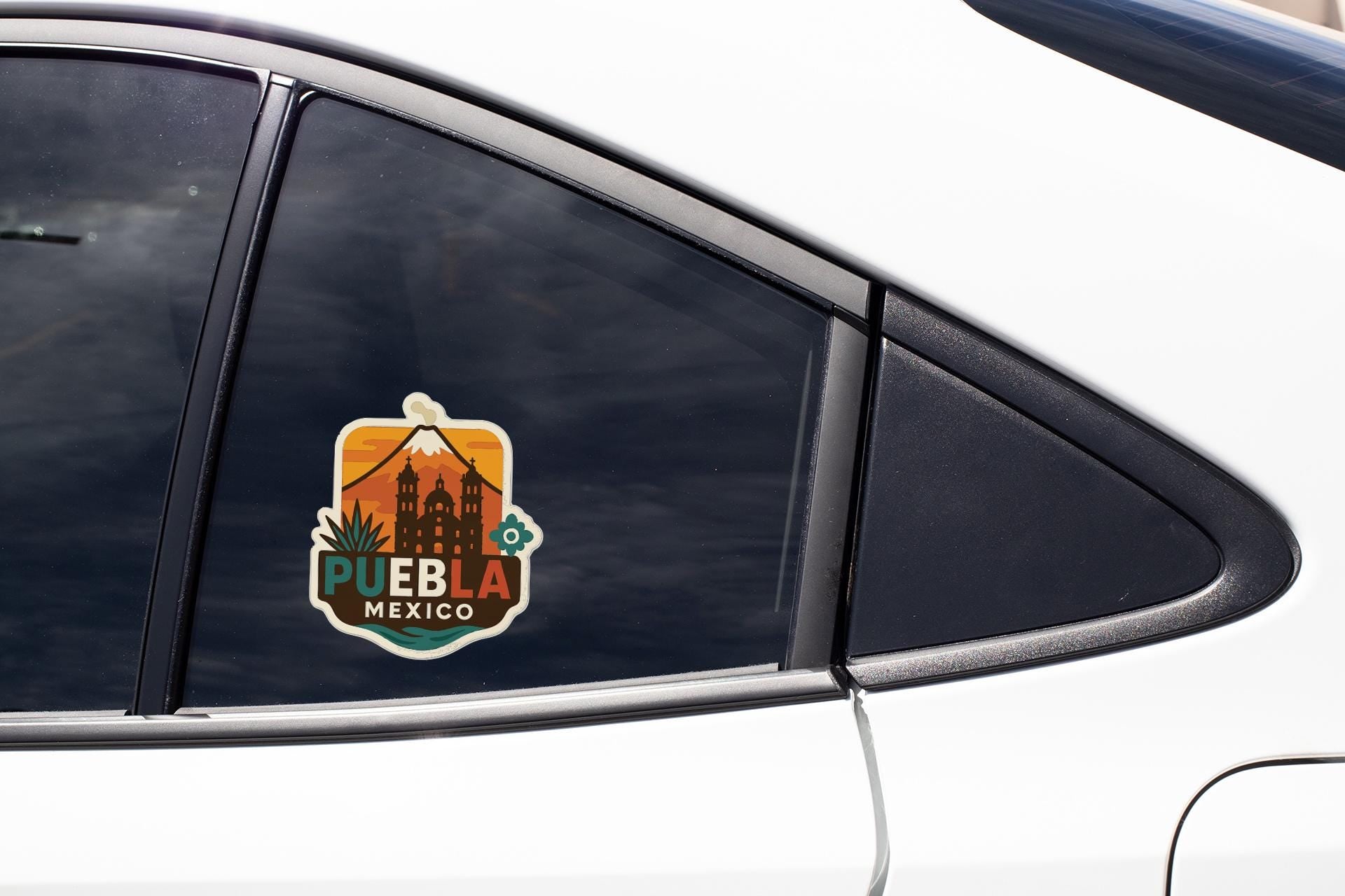 A sticker on the side of a car window that says "PUEBLA MEXICO".