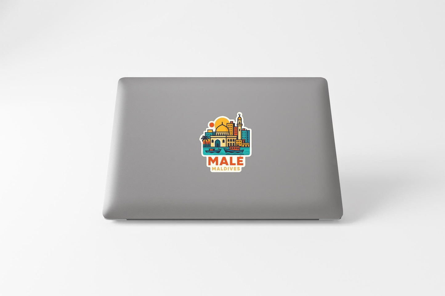 a sticker with a colorful illustration of a cityscape on the back of a laptop.