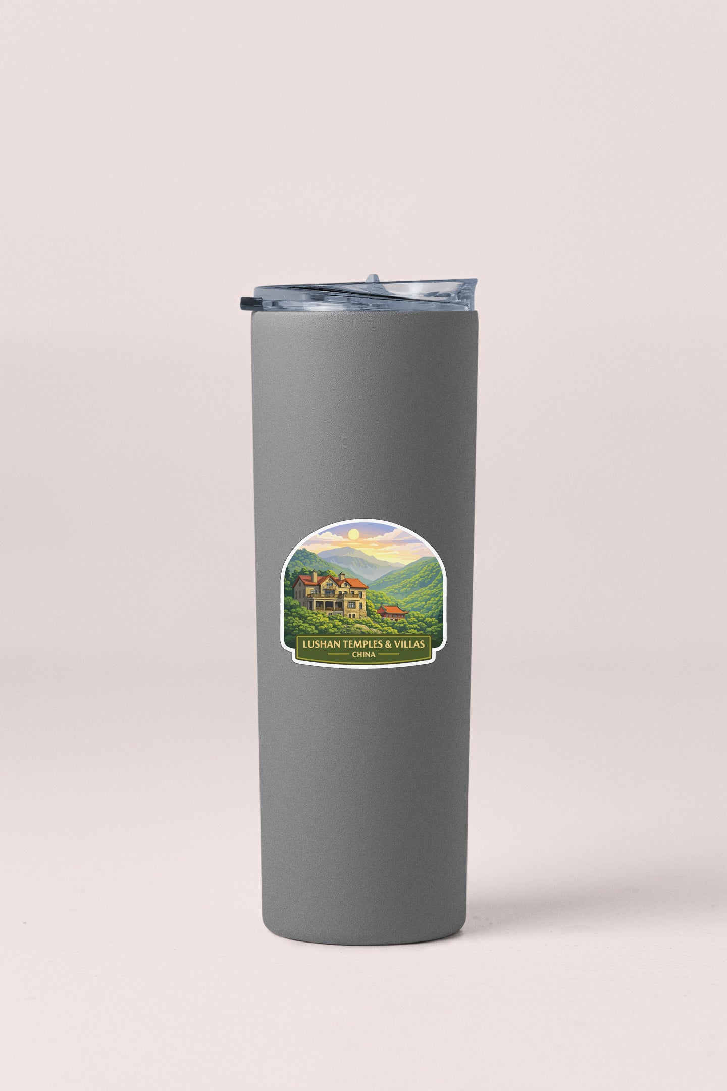 A gray insulated tumbler with a lid and a label featuring a scenic mountain landscape.
