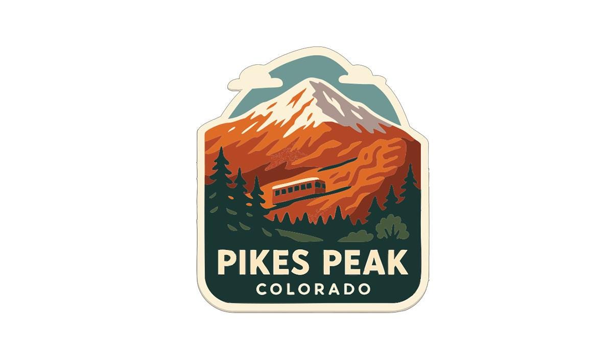 A sticker or emblem featuring a mountain landscape with a train traveling along a track, surrounded by pine trees and mountains.